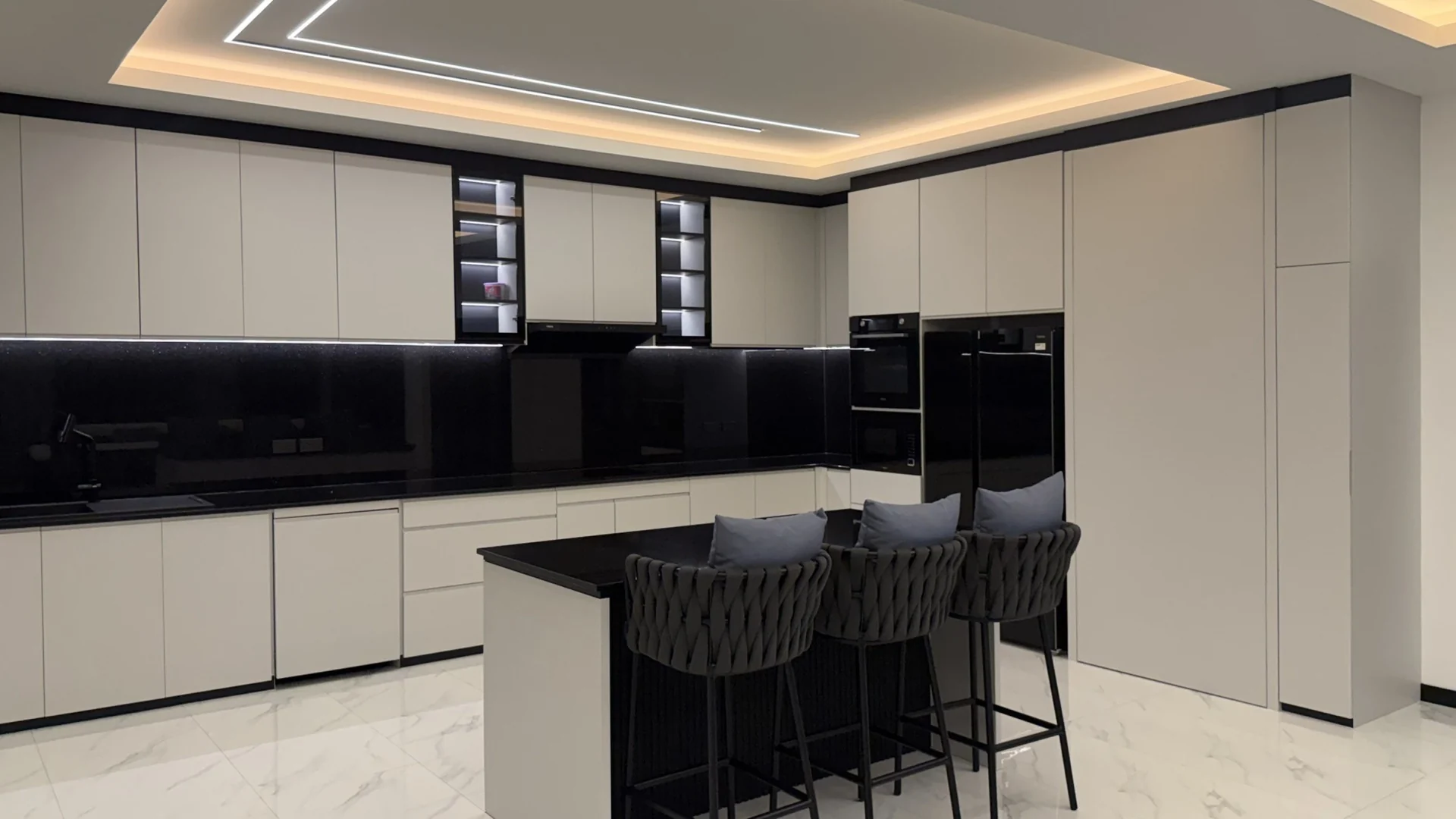 The kitchen at night with every cabinet closed and the LED ceiling lines on